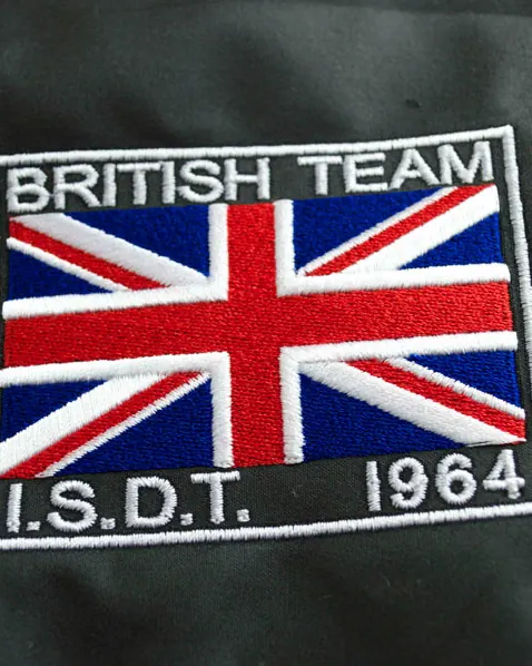 Embroidered British team crest patch with a Union flag and date, sewn to a jacket.