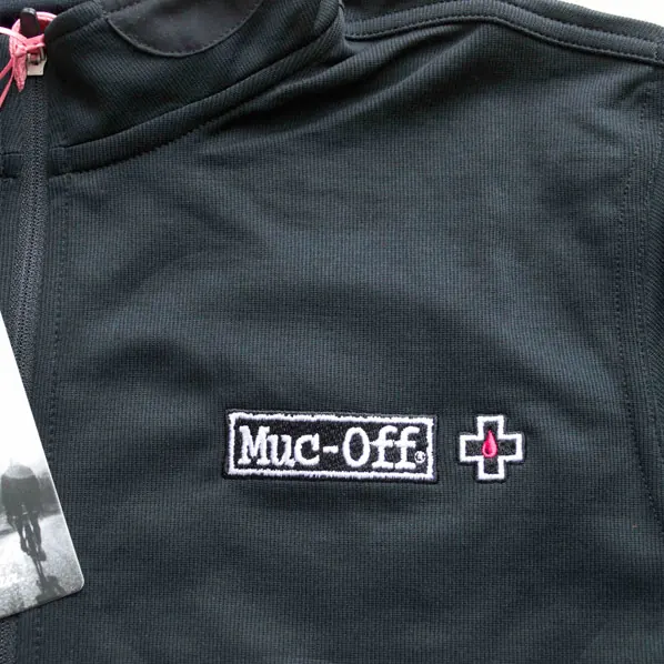 Sports brand logo embroidered in white on a black technical training top.